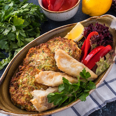 Fried fish with zuccini pancakes. Closeup
