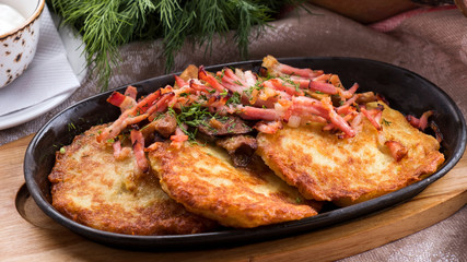 Potato pancakes with bacon and mushrooms. Closeup