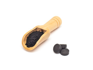 Black activated carbon tablets and powdered carbon on a white background concept of use in cosmetology and dermatology, white background, isolate, anti-inflammatory