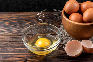 Raw eggs on dark wooden background.