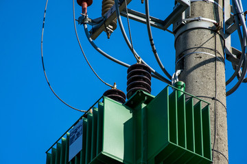 Detail of a transformer on electric pole with insulators