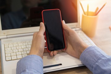 hand closeup with mobile phone and computer