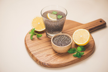 Selective focus of chia seeds drink with water in transparent glass with lemon balm.