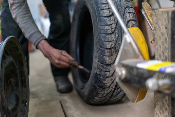 Fototapeta na wymiar Replace tire on wheel in auto repair service