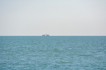 Fishing vessels with exhaust plume visible on the horizon in the Gulf of Mexico off the coast of Florida