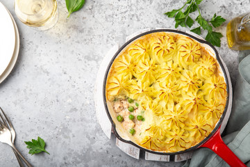 Salmon, mashed potatoes and vegetables casserole in enamel cast iron pan