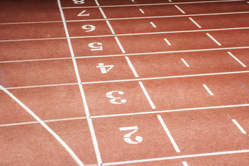 Fototapeta premium From above view of enumerated running tracks at sports venue with nobody on them