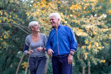 Two aged couple jogging in park