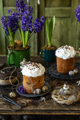 Easter bread with sugar glaze and dried fruits, dark rustic background with  vintage Easter decoration and spring hiacinth flowers