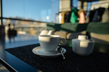 white cup with kettle on cafe table