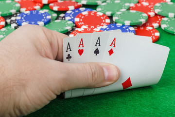 Hand with playing cards in casino