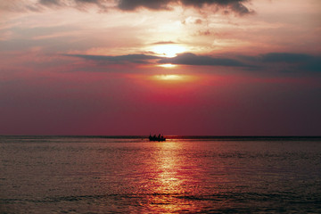 Naklejka na ściany i meble Thailand sea in evening with sun set and small boat in the middle the sea during twilight sky