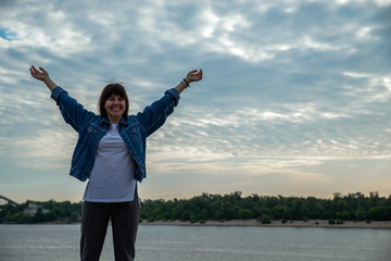 young smiling pretty woman at riverside on sunrise