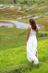 Fototapeta na wymiar Young brunette woman turning her back posing against the background of rice fields