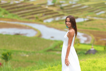 Tanned young woman posing on the background of rice fields. Close up