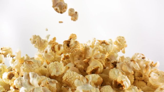 Delicious popcorn falling, landing and gathering in slow motion