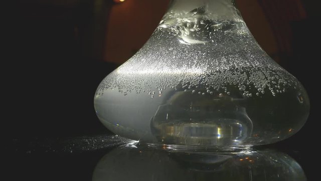 transparent hookah base filled with water, smoke and air bubbles. Moment of smoking