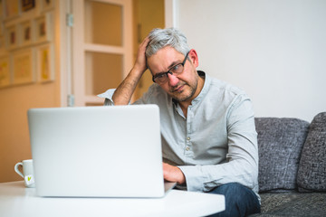 browsing online news. man relaxing at his home
