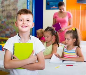 Glad boy pupil standing in elementary school class