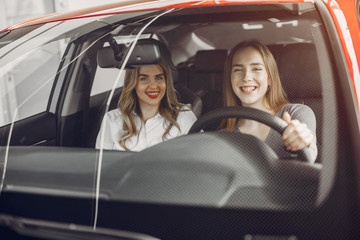 Women buying the car. Ladies in a car salon