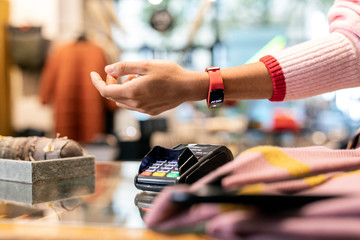 Customer paying contactless with her smartwatch