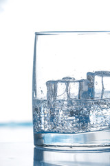 clear water with bubbles ice cubes in glass close up vertical composition