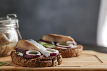 traditional scandinavian sandwich smorrebrod with herring red onion rye bread on cutting board close up selective focus