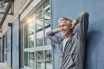 Portrait of laughing mature man in front of gym