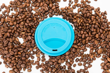 Top View of Silicone Coffee Cup Lids On Coffee Beans on White Background
