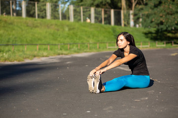 Young fitness woman runner doing stretching before workout. Outdoor shot with sun rays. Space for text