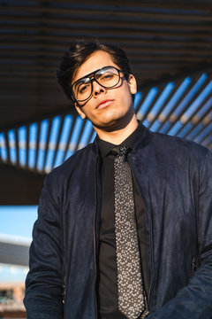 Portrait of fashionable young businessman wearing glasses and tie