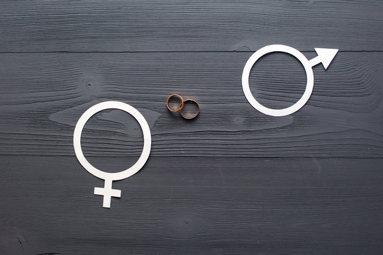 wedding rings on the beautiful hardwood background, the concept of gender equality