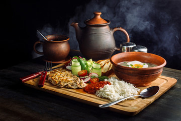 Laid dinner on the table, onion and egg soup, rice, chicken breast.
