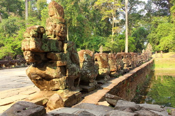 Old stone bridge decorated with ruined statues to the Preah Khan Temple at Angkor Wat complex in Siem Reap, Cambodia. World Heritage Site by UNESCO. Ancient Khmer architectural monument