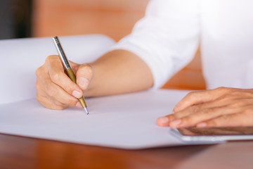 Selective focus of Casual young business man hand using mobile smart phone with pen blurred background