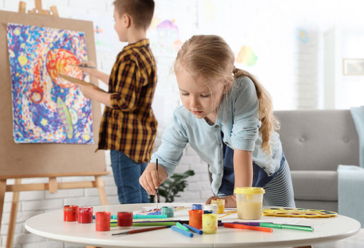 Cute little children painting together at home
