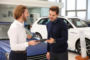 Car salesman working with customer in dealership