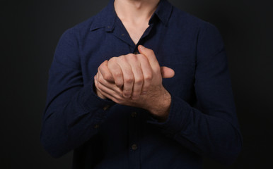 Man showing BELIEVE gesture in sign language on black background, closeup