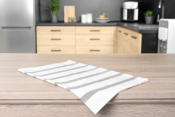 Napkin on wooden table in kitchen. Mockup for design
