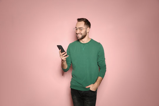 Handsome Young Man With Mobile Phone On Color Background