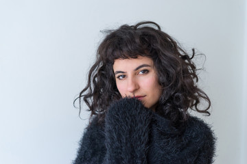 A serious woman covering her face with a sweater