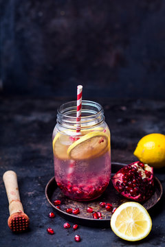 Fruit infused water with lemon slices, crushed pomegranate seeds and sparkling water