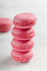 Fototapeta na wymiar Pink macaroons on a stone background stacked. Sweet treat, biscuits, high-calorie food