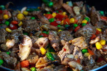 veal meat stew in a skillet with vegetables in sour cream sauce