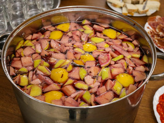 Big pot of sangria. Apples, lemons, oranges with red vine and juice.