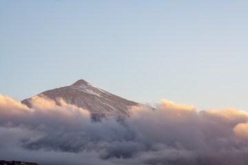 snowy mountain at sunset with clouds shrouded