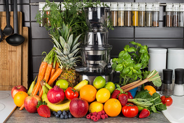 slow juicer in kitchen with many fruit and vegetable juice healthy lifestyle concept background