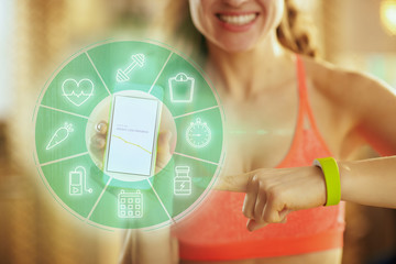 Closeup on phone screen with fit app in hand of happy fit woman