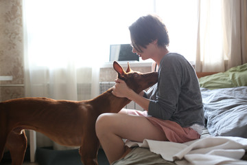 woman with Pharaoh's dog is hugging and raising