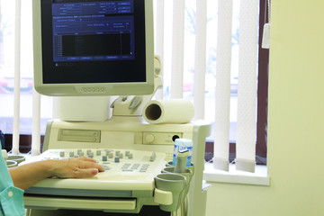 Fototapeta na wymiar Doctor providing ultrasound diagnostics in hospital cabinet